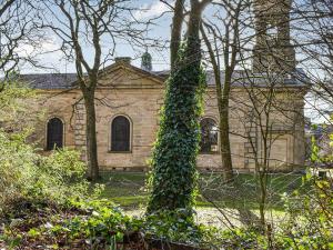 an ivy covered tree in front of a building at No1 Park Lodge in Buxton