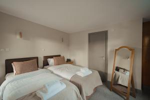 a bedroom with two beds and a mirror at Old Mill Hotel & Lodge in Bath