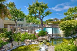 a garden with a waterfall and a fence at Oceanfront Luxury, Fully Remodeled, Five-Star in Solana Beach