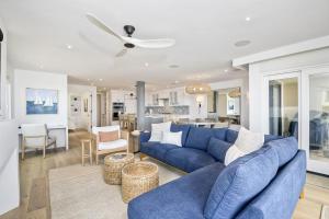 a living room with a blue couch and a kitchen at Oceanfront Luxury, Fully Remodeled, Five-Star in Solana Beach