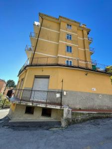 a yellow building with a balcony on the side of it at Zena in Genoa