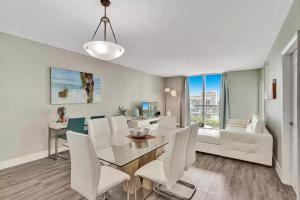 a dining room with a table and white chairs at Amazing Apartment on hollywood beach TIDES in Hollywood