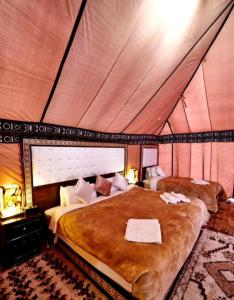 a bedroom with a large bed in a tent at Luxury Desert Camp in Merzouga