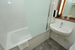 a white bathroom with a sink and a shower at Campanile Nice Aéroport in Nice