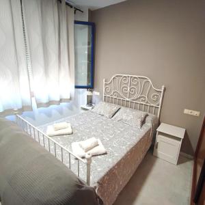 a bedroom with a bed with two towels on it at Apartamento FIBES edificio LUX SEVILLA in Seville