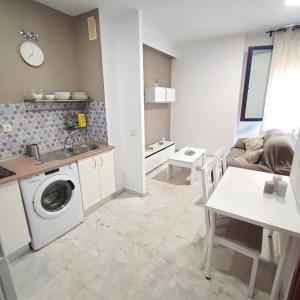 Apartamento FIBES edificio LUX SEVILLA في إشبيلية: مطبخ وغرفة معيشة مع غسالة ملابس