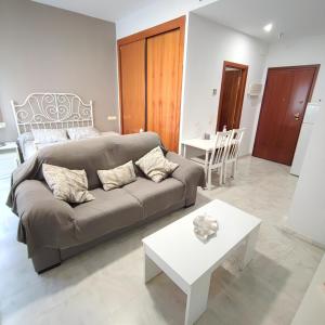 Apartamento FIBES edificio LUX SEVILLA في إشبيلية: غرفة معيشة مع أريكة وطاولة