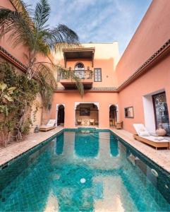 a swimming pool in front of a house at Palais Riad Lamrani in Marrakesh