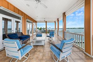 a porch with blue chairs and a view of the water at Eagle's Nest in Gulf Shores +31 photos