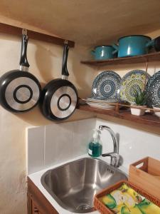 a kitchen sink with pots and pans hanging above it at Casa Lanzara in Morano Calabro