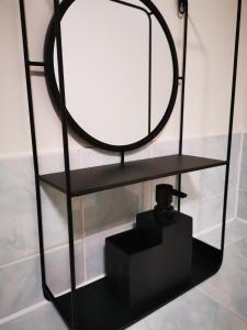 a black shelf with a mirror and a black box at City Centre Comfort in Southampton