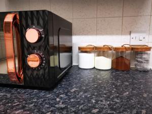 a microwave on a counter next to jars of food at City Centre Comfort in Southampton