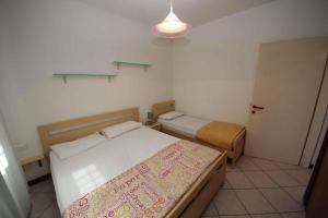 ロゾリーナ・マーレにあるApartment in Rosolina Mare 25019の小さなベッドルーム(ベッド2台、照明付)
