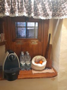 a shelf with bottles of water and a bowl of oranges at Casa Lanzara in Morano Calabro