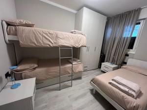 1 dormitorio con 2 literas y escritorio en Appartamento Grigna2410 - Primaluna, en Primaluna