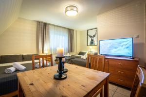 a living room with a television and a table with a candle at Liberta INN - Pokoje Gościnne in Zakopane