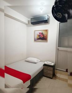 a small bedroom with a bed and a window at Hotel Gueicer Cucuta in Cúcuta