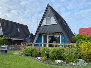 una casa con techo de gambrel y jardín en Murmel 2 - Wallbox, WLan, Kamin en Greetsiel