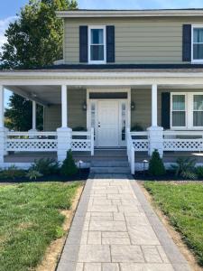 a house with a white front door and a porch at Country Squire Inn and Suites in New Holland