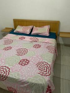 a bed with a pink and white blanket and pillows at Residence Nadia in Tabarka