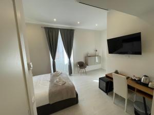 a bedroom with a bed and a desk and a television at Quintus Luxury Suites in Rome
