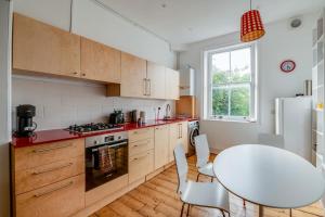 a kitchen with a white table and a white refrigerator at Bright Two Bedroom Apartment Near Vibrant Camden Town in London