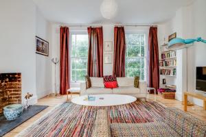 a living room with a couch and a table at Bright Two Bedroom Apartment Near Vibrant Camden Town in London