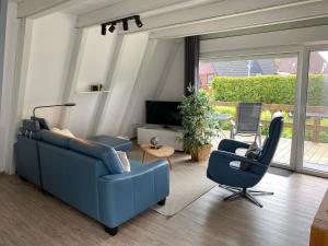 sala de estar con sofá azul y silla en Murmel 2 - Wallbox, WLan, Kamin, en Greetsiel