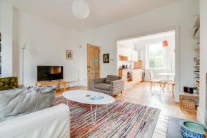 a living room with a white couch and a table at Bright Two Bedroom Apartment Near Vibrant Camden Town in London