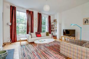 a living room with a couch and a table at Bright Two Bedroom Apartment Near Vibrant Camden Town in London