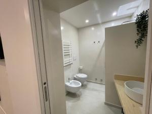 La salle de bains blanche est pourvue de toilettes et d'un lavabo. dans l'établissement Quintus Luxury Suites, à Rome