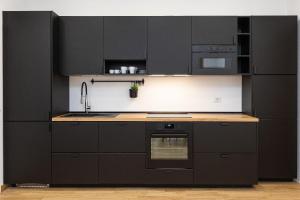 Augusto Imperatore by Rental in Rome في روما: مطبخ بدولاب سوداء وقمة كونتر