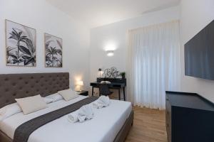 Augusto Imperatore by Rental in Rome في روما: غرفة نوم بها سرير ومكتب وتلفزيون