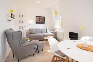 a living room with a table and chairs and a couch at Wertschätzer II - Unter der Wehme in Detmold