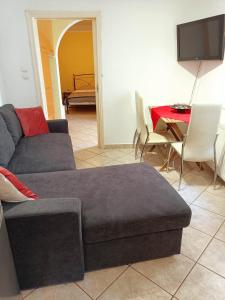 uma sala de estar com um sofá e uma mesa em Detached house with a lovely yard 5' walk from Metro Station Agios Dimitrios and METRO MALL em Atenas