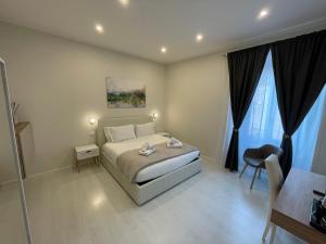 a bedroom with a bed and a table and a chair at Quintus Luxury Suites in Rome