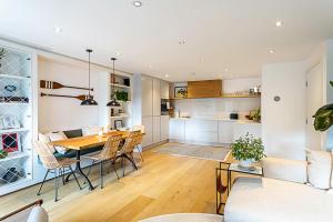 a kitchen and dining room with a table and chairs at Slick apartment In Quaint Battersea Square in London