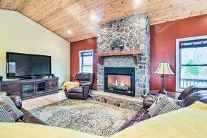 a living room with a stone fireplace and a tv at Cozy Home with Patio, 2 Mi to Dale Hollow Lake! in Frogue