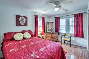 a bedroom with a red bed with a ceiling fan at Charming Beaufort Getaway Walk to the Waterfront! in Beaufort