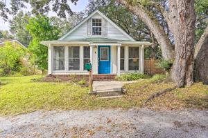 a small white house with a blue door at Cozy Home with Yard about 9 Mi to Dtwn Charleston! in Charleston