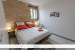 ein Schlafzimmer mit einem Bett mit roten Kissen in der Unterkunft Le Cosy-vergerentre2mers in Langoiran