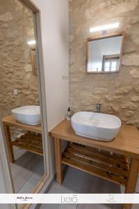 a bathroom with two sinks and a mirror at Le Cosy-vergerentre2mers in Langoiran