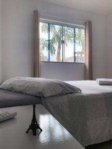 a bedroom with a large bed with a window at Casa Premium em Balneário Gaivota in Sombrio