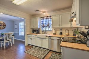 a kitchen with white cabinets and a dining room at Charming Newnan Getaway about Mins to Downtown! in Newnan