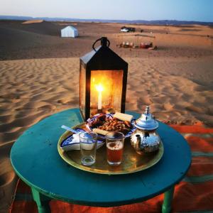 a plate of food on a table in the desert at Authentique berber Camp in Mhamid