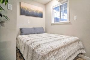a bedroom with a bed with a blanket and a window at Adorable Studio Cottage Walkable to Town! in Grants Pass
