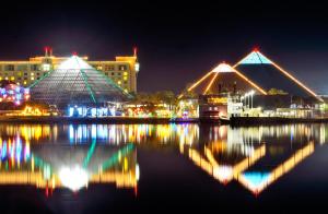 uma vista noturna de uma cidade com edifícios e a água em Moody Gardens Hotel Spa and Convention Center em Galveston