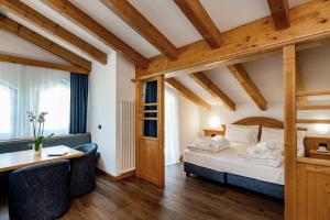 een hotelkamer met een bed en een bureau bij Hotel Terme Antico Bagno in Pozza di Fassa