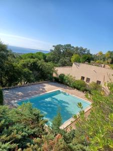 vista sul tetto di una piscina di fronte a una casa di APPARTEMENT CLIMATISE - TERRASSE AVEC APERCU MER - GOLF DE ST TROPEZ a Les Issambres