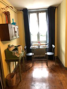 ein Esszimmer mit einem Tisch und einem Fenster in der Unterkunft Les Forges in Saint-Sornin-la-Marche